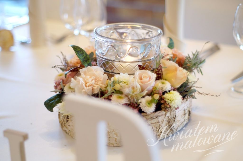 Dekoracja kwiatowa na stole w sali weselnej