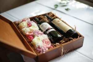 Butelki wina w pudełku i kwiatach